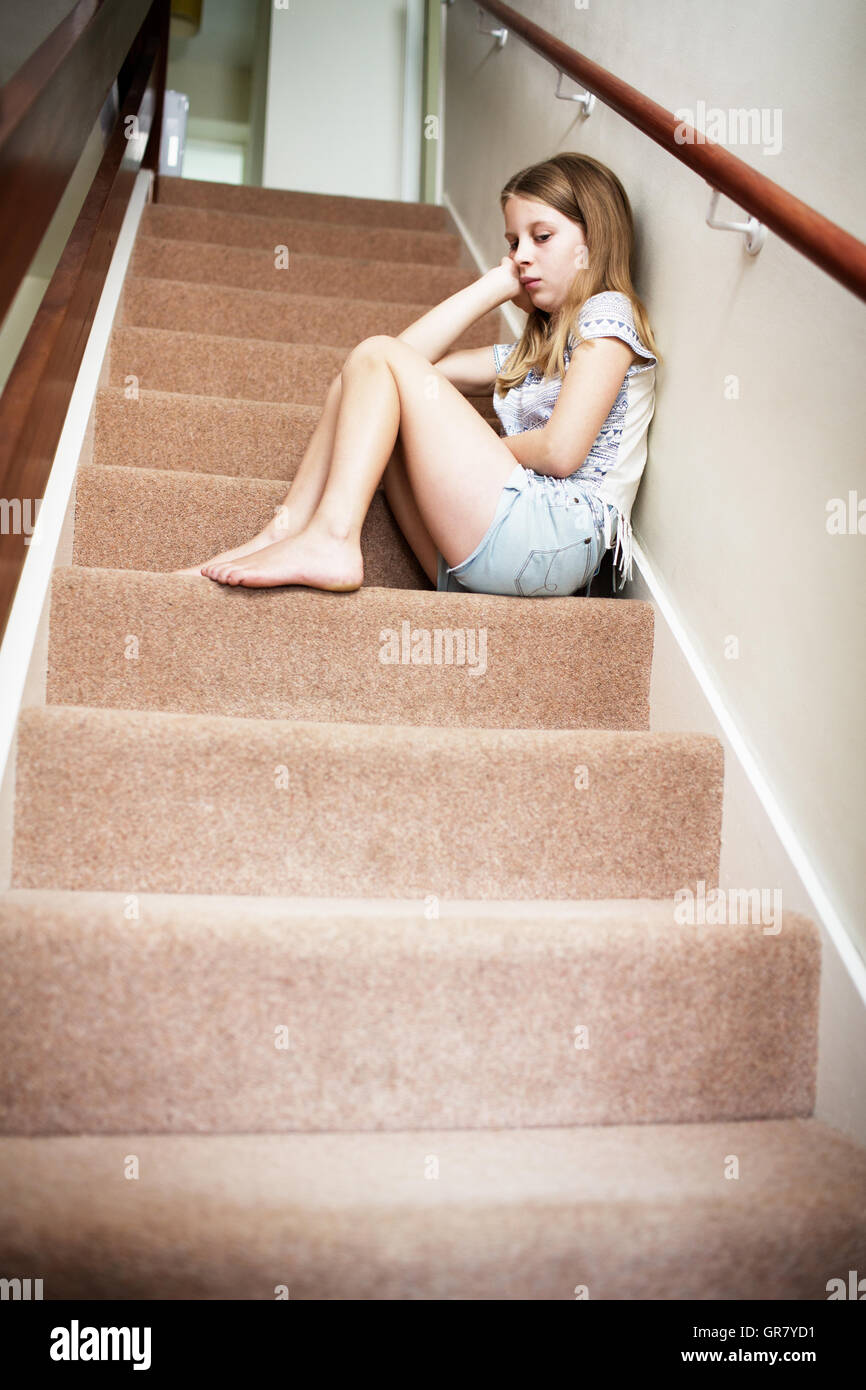 Unglückliche Mädchen sitzen auf Treppen zu Hause Stockfoto