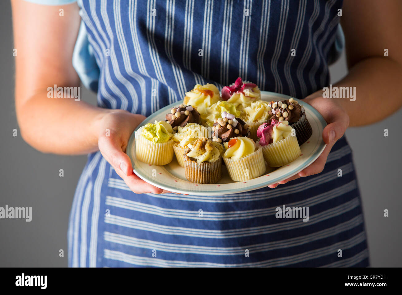 Frau hält Teller mit leckeren hausgemachten Muffins Stockfoto
