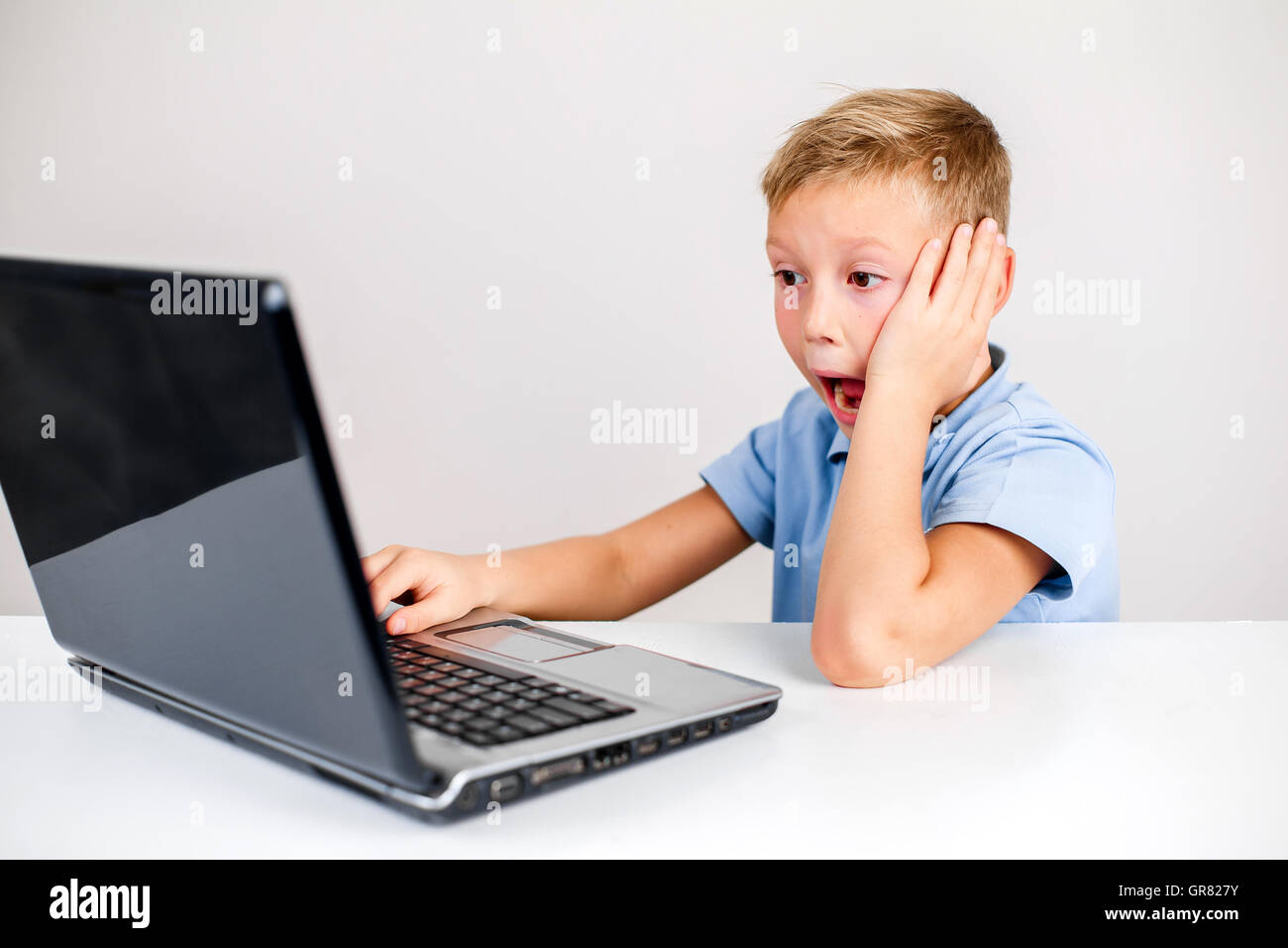 schockiert junge mit Laptop mit offenem Mund Stockfoto