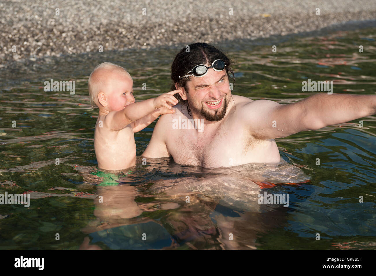 Vater mit ihrem Kleinkind Jungen in einem Meer in Sistiana, Friaul-Julisch Venetien, Italien, Europa Stockfoto