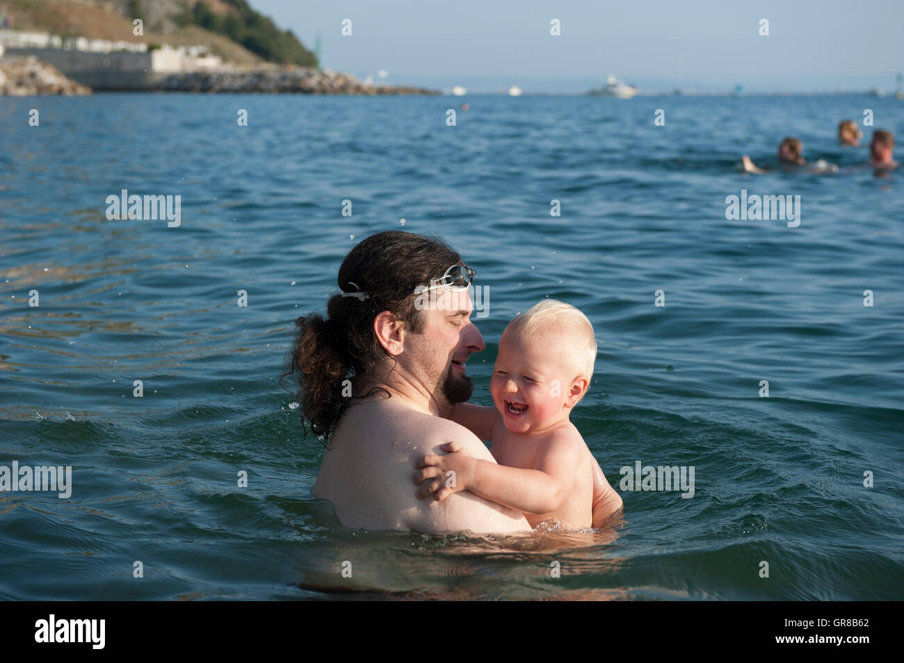 Vater mit ihrem Kleinkind Jungen in einem Meer in Sistiana, Friaul-Julisch Venetien, Italien, Europa Stockfoto