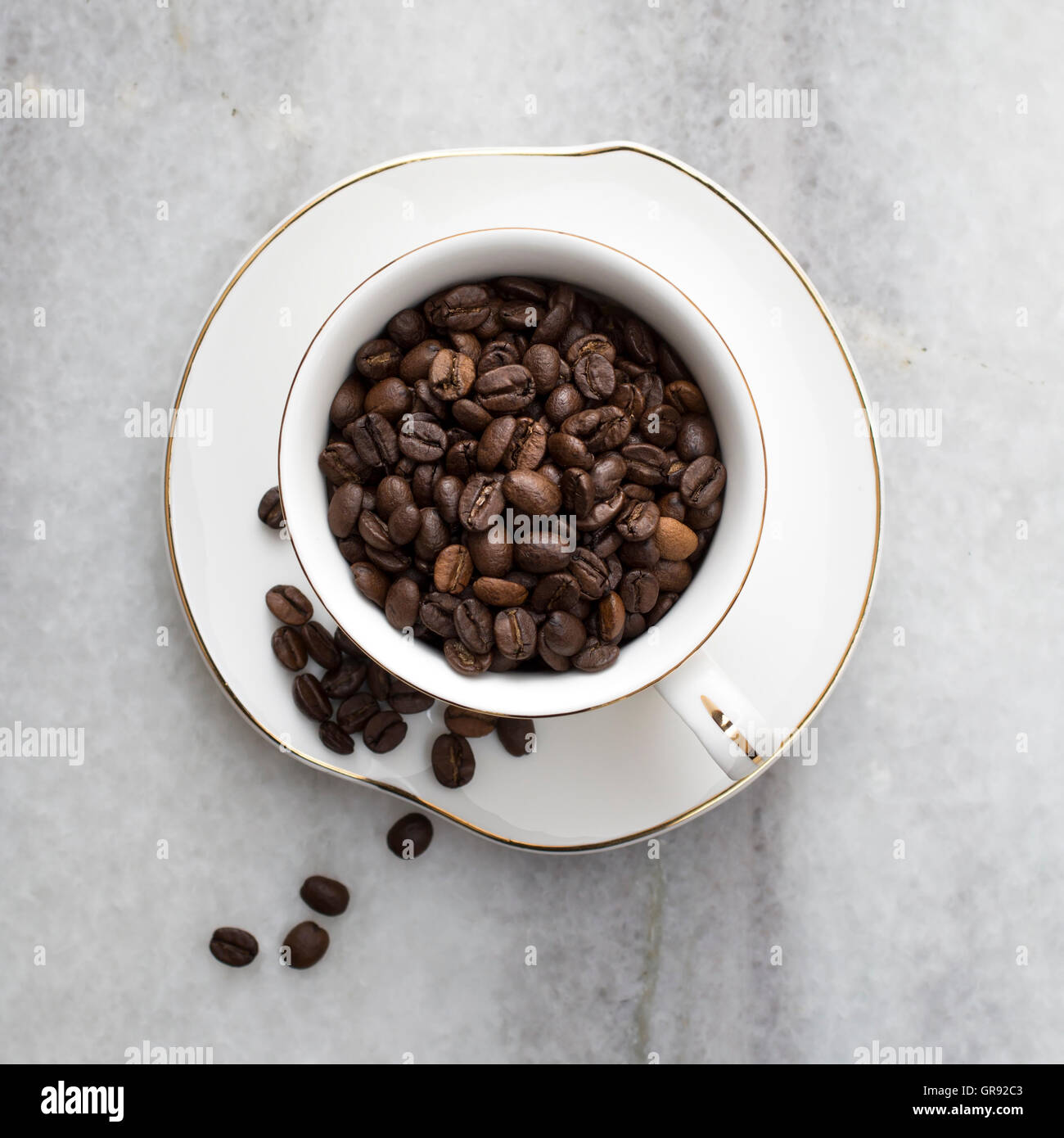 Tasse voll Kaffee Bohnen auf dem Marmor Hintergrund Stockfoto