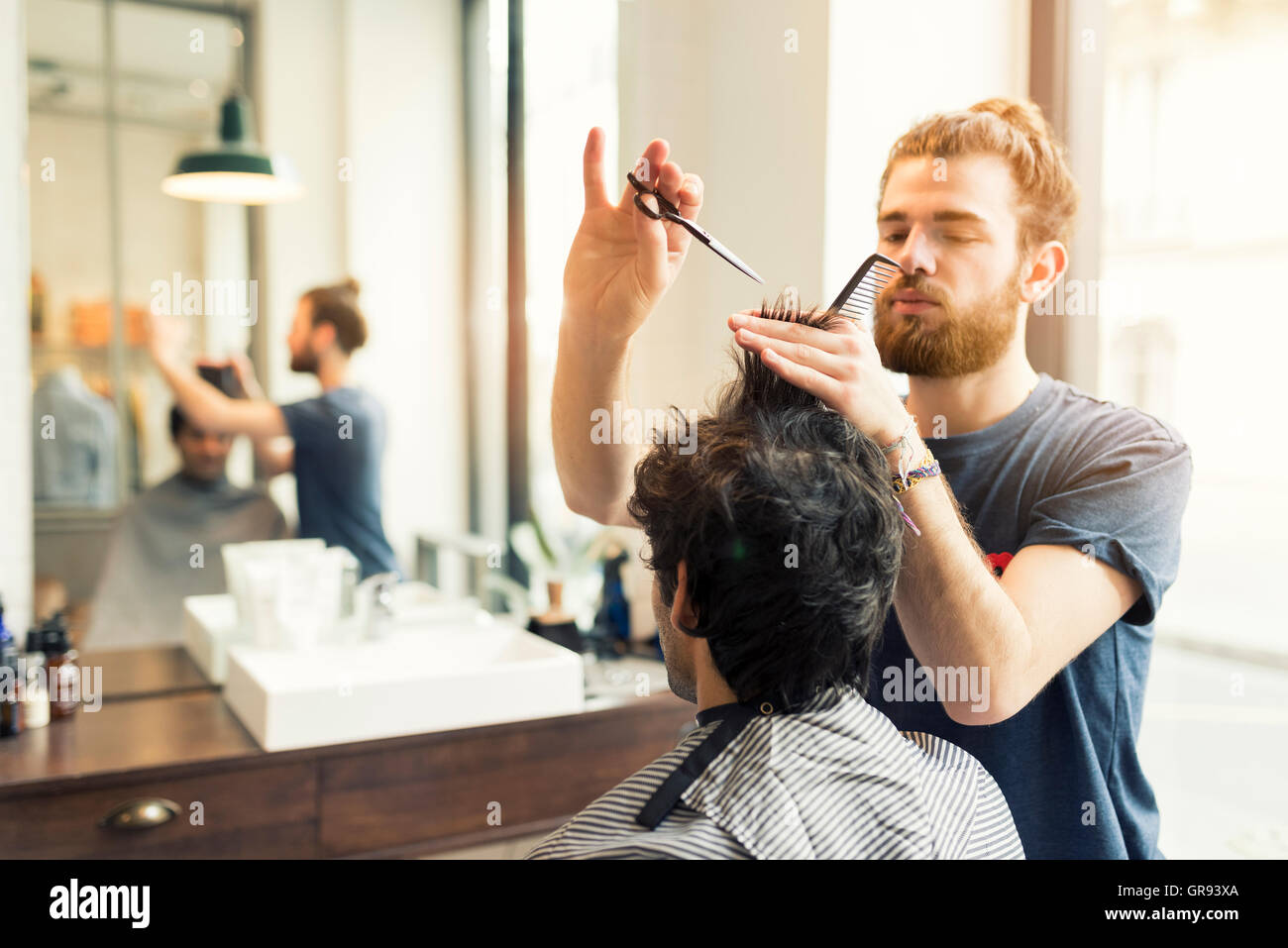 Mann bekommt einen Haarschnitt an seinem Barbier Stockfoto