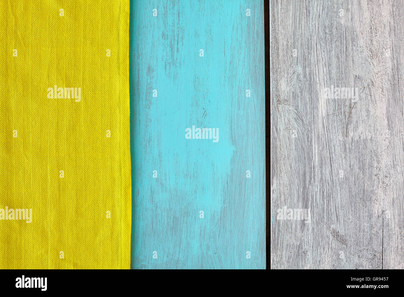 Rustikale blau und weiß lackierten Holztisch mit einer gelben Tischdecke, Ansicht von oben, Textfreiraum. Stockfoto