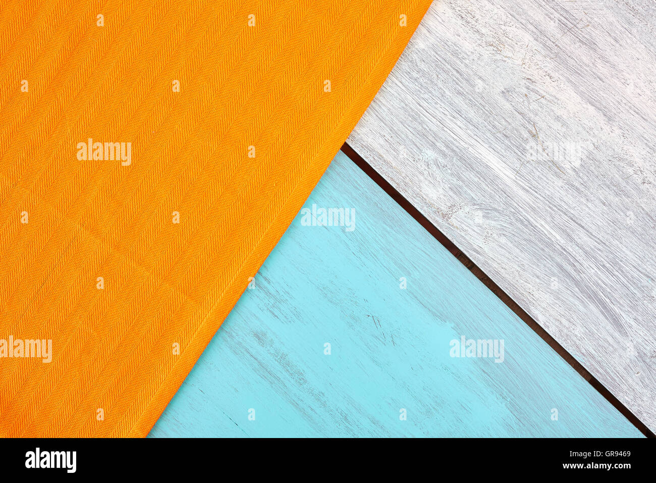 Rustikale blau und weiß lackierten Holztisch mit orange Tischdecke, Ansicht von oben, Textfreiraum. Stockfoto