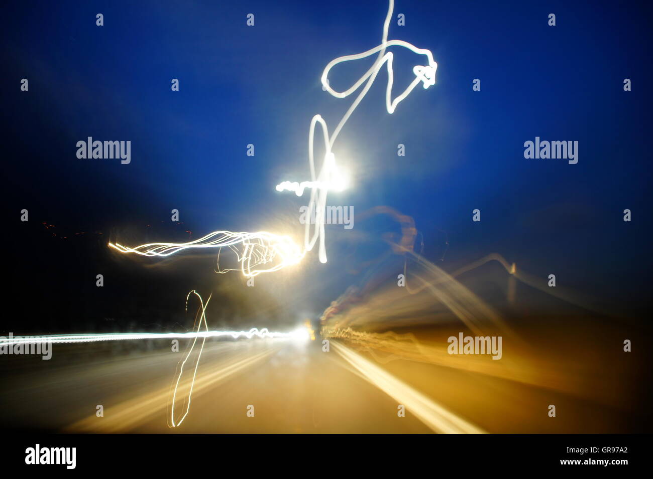 Licht In der Dämmerung mit langer Belichtungszeit während der Fahrt Stockfoto