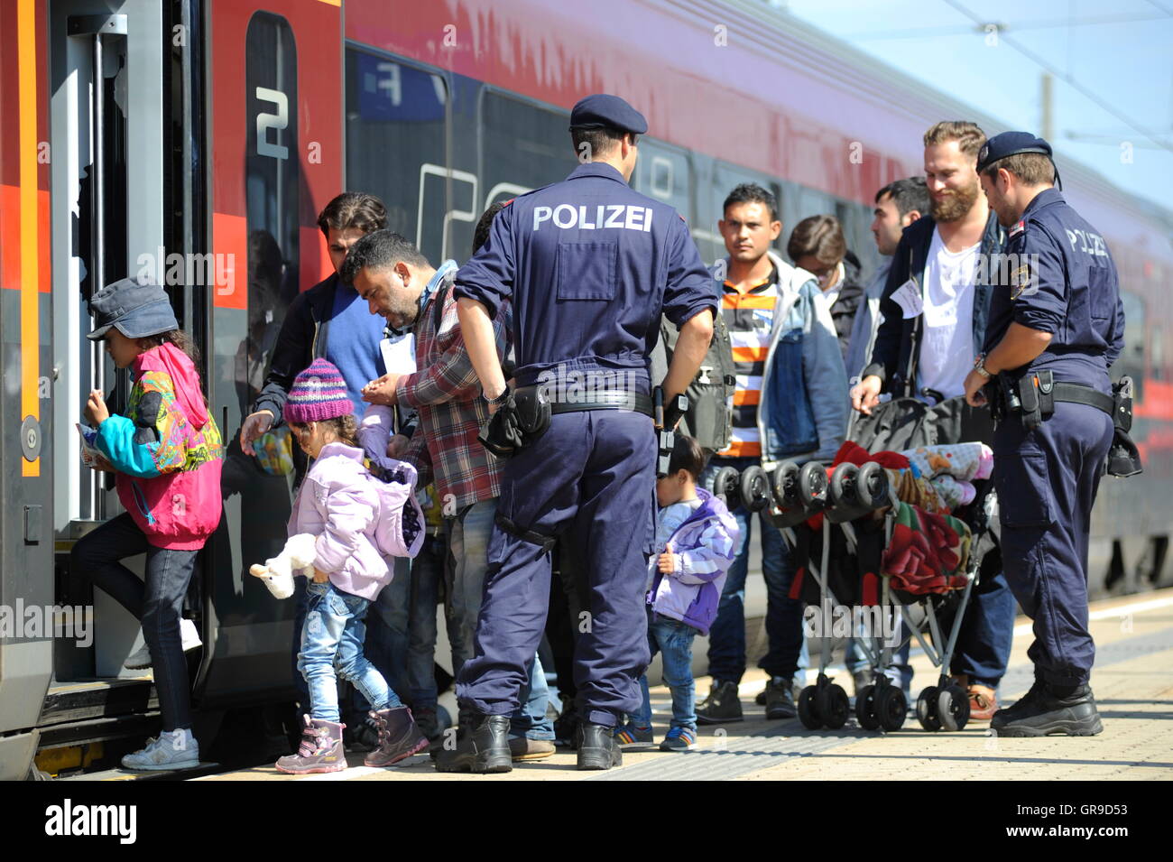 Syrische Flüchtlingsfamilie am Westbahnhof In Wien begleitet von der österreichischen Polizei-Vorstand einen Zug nach Deutschland. Stockfoto