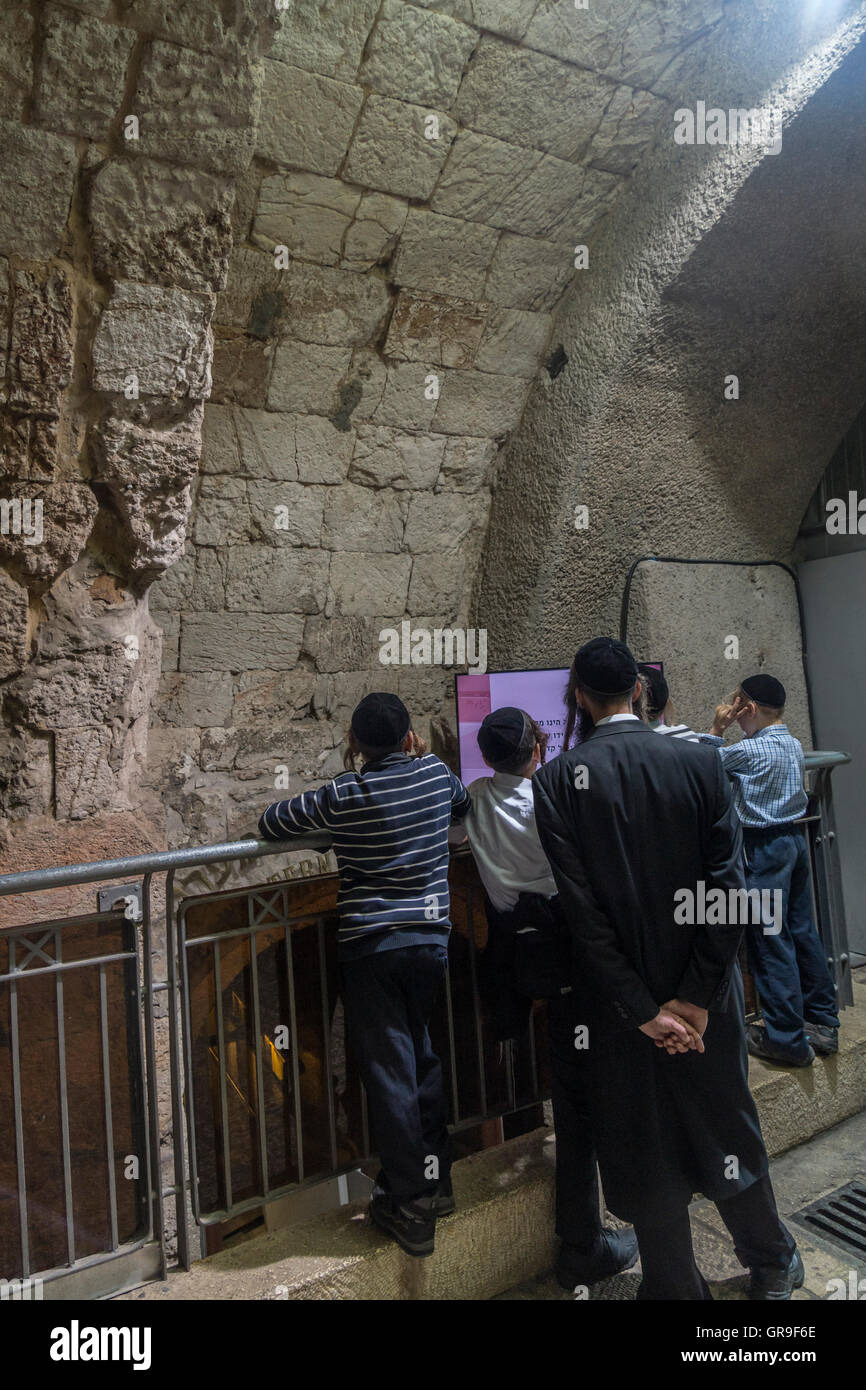 Jerusalem, Israel. Ein ultra-orthodoxe Juden ('Haredi") Vater und seine Söhne Ansicht ein pädagogisches Programm in einem Tunnel in der Nähe der Einfahrt zum westlichen Wand Stockfoto