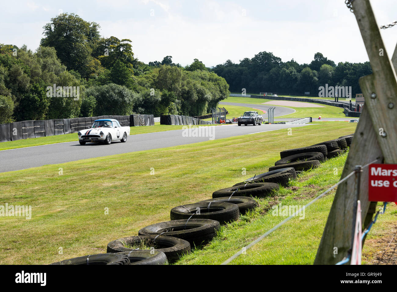 Ein Sunbeam Alpine und Triumph TR5 in Hill Top bei einem historischen Rennen auf der Oulton Park Motor Racing Circuit in der Nähe von Tarporley Cheshire England Vereinigtes Königreich Großbritannien Stockfoto