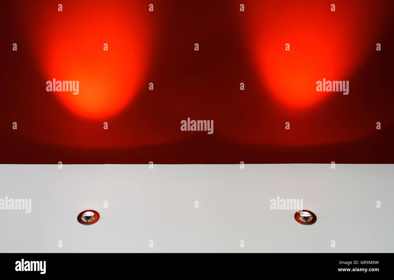 Zwei Scheinwerfer leuchten auf einer roten Decke Stockfoto