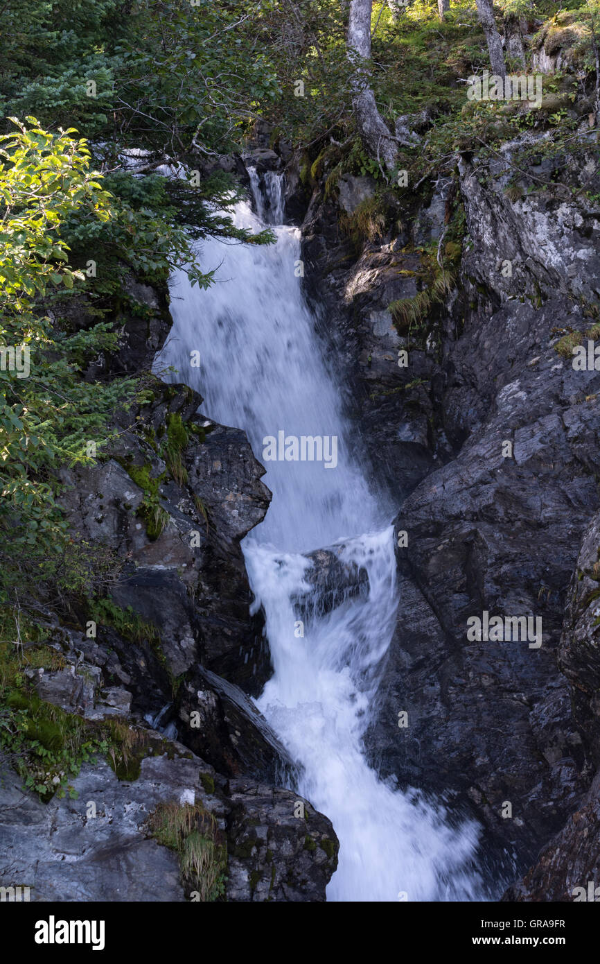 Wasser rauscht durch einen Riss im Felsen einen versteckten Wasserfall zu schaffen. Stockfoto
