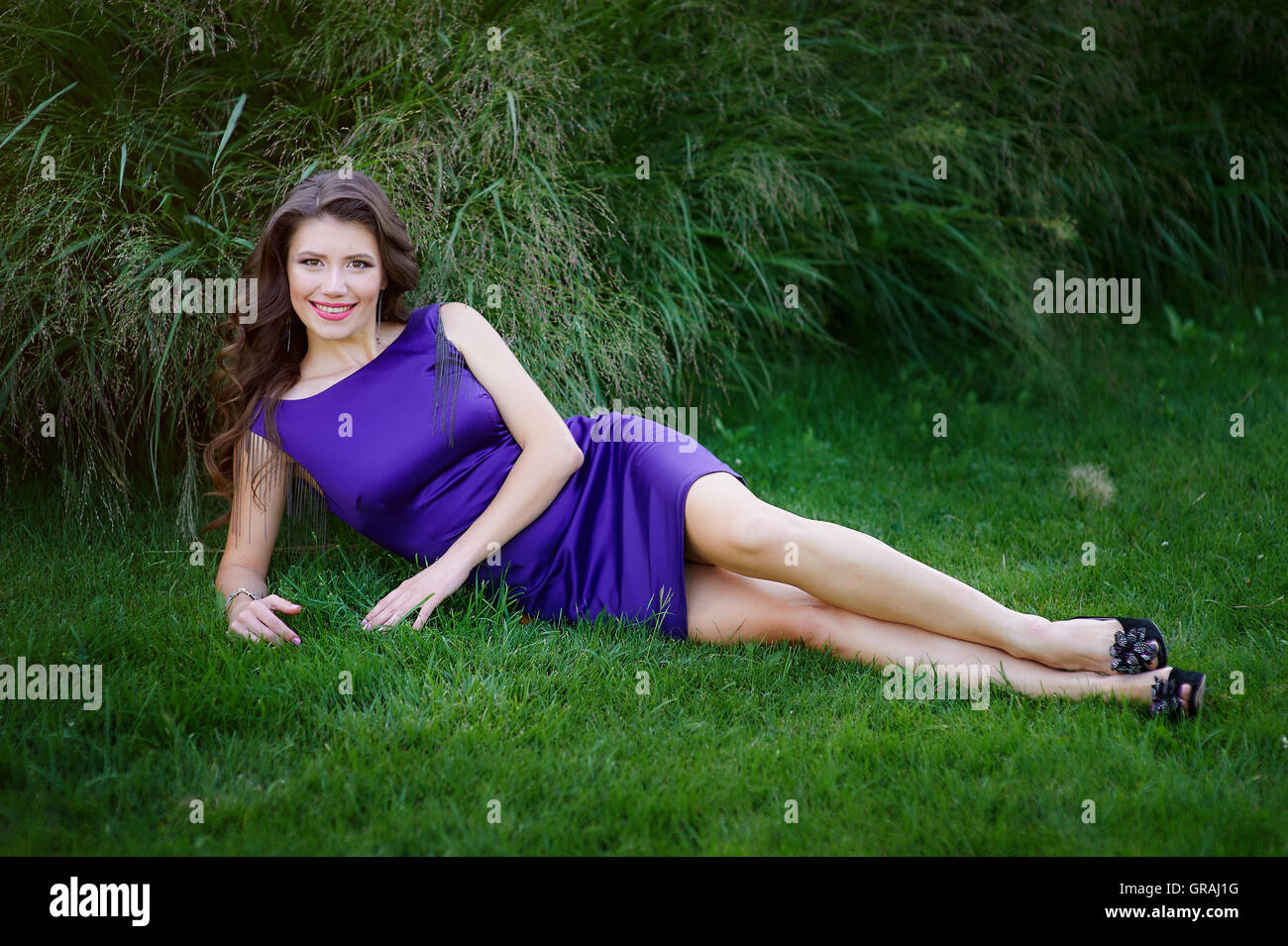 schöne Frau liegend auf dem grünen Rasen im park Stockfoto