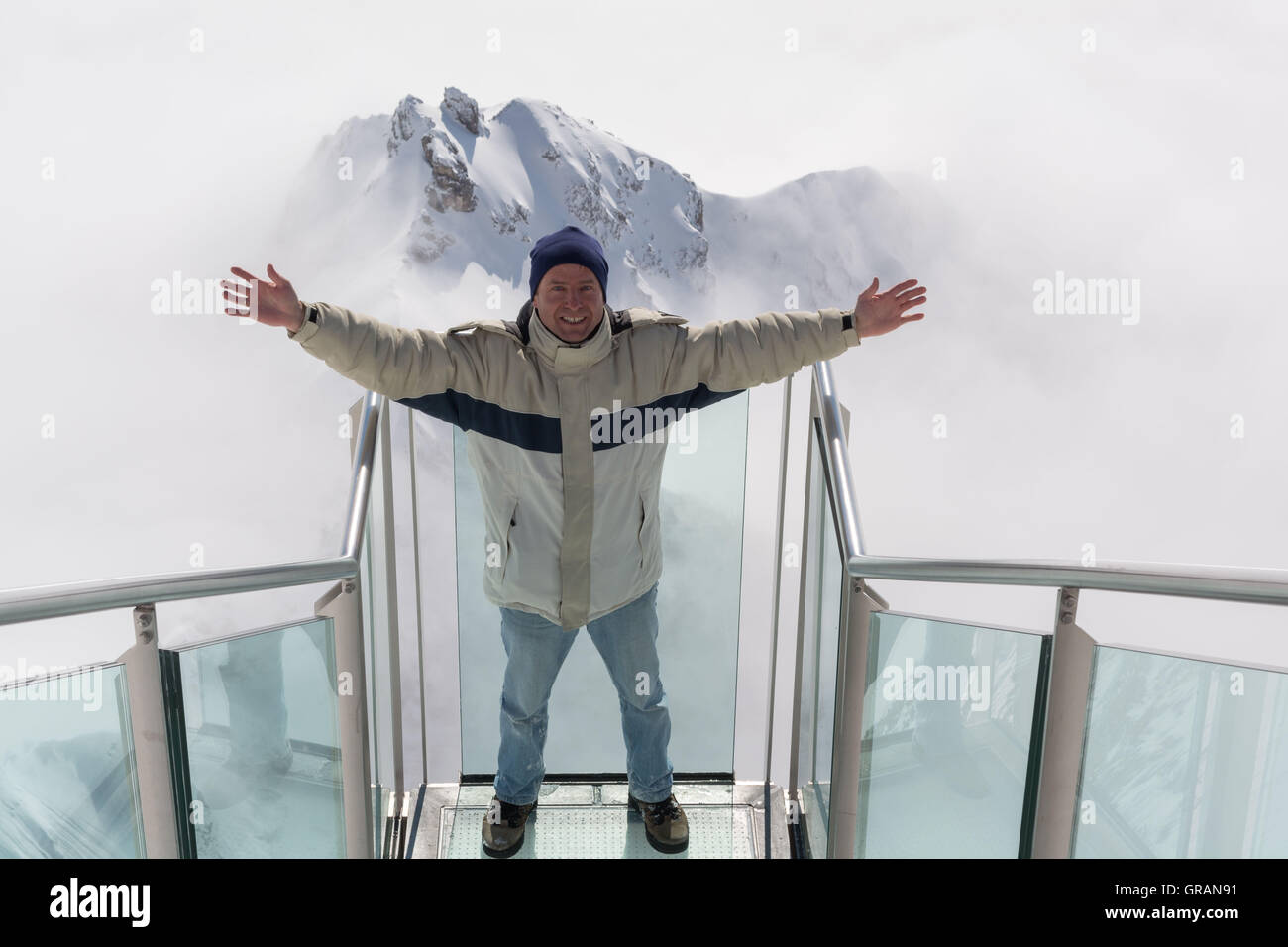 Mann genießt auf der Treppe ins nichts auf das Dachsteingebirge Stockfoto