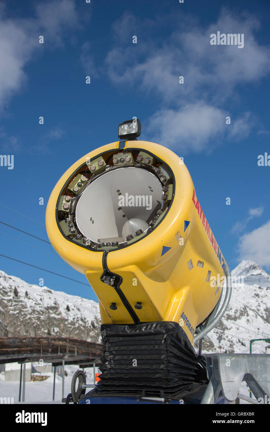 Inaktive gelb Schneekanone gegen blauen Himmel im Hintergrund Schnee bedeckt Berge Stockfoto