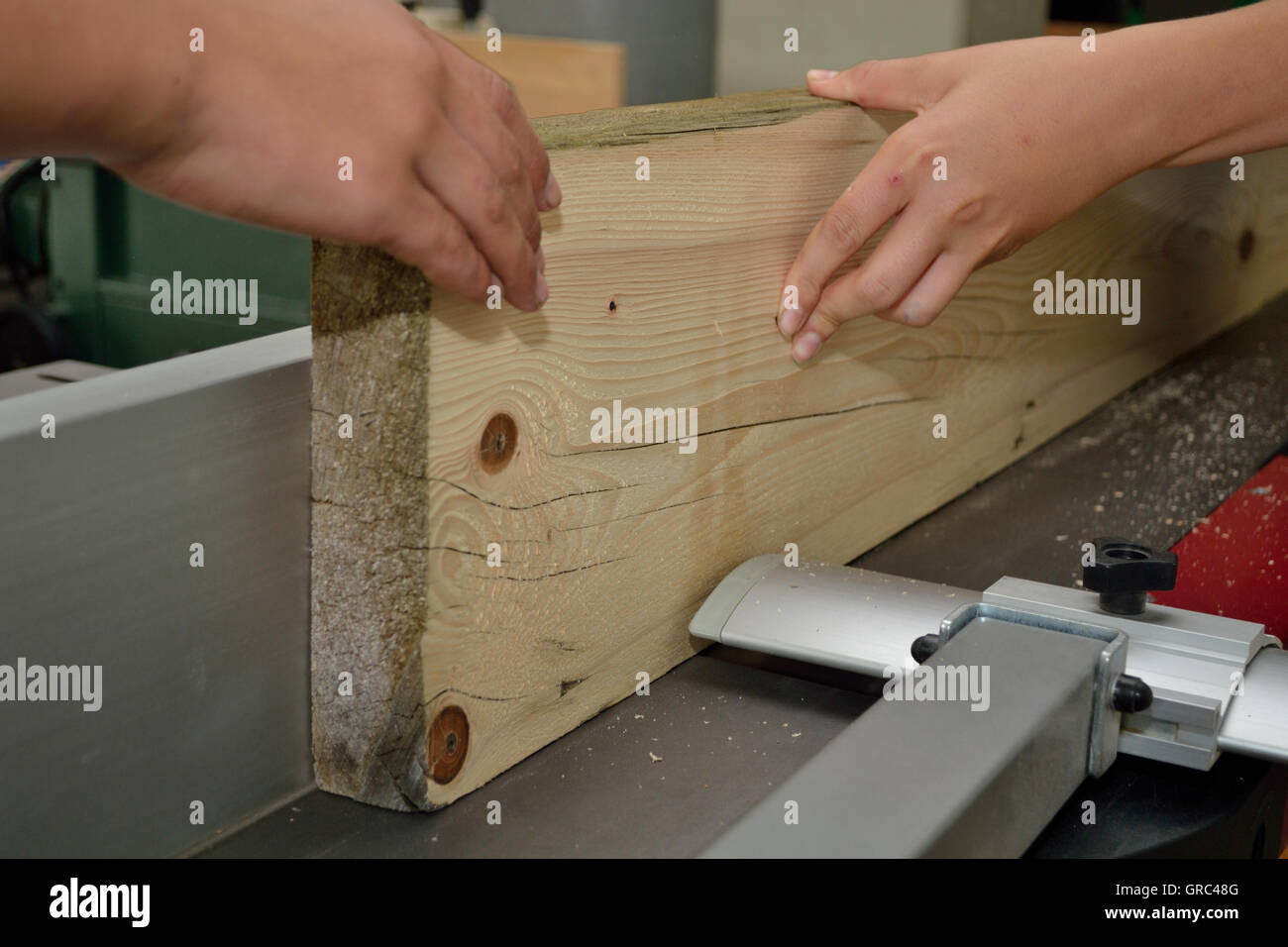 Holzbrett wird vom Tischler mit einer Fräse behandelt. Stockfoto