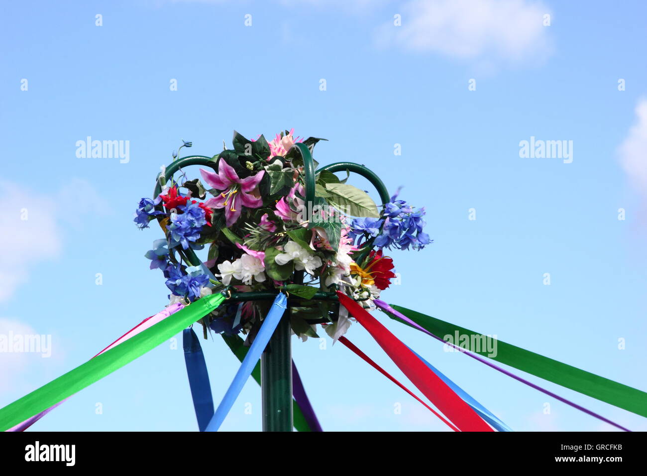 Satinbänder erstrecken sich von der Blume Krone an der Spitze der ein Maibaum als ein traditioneller Britishfolk-Tanz im Gange, England UK bekommt Stockfoto