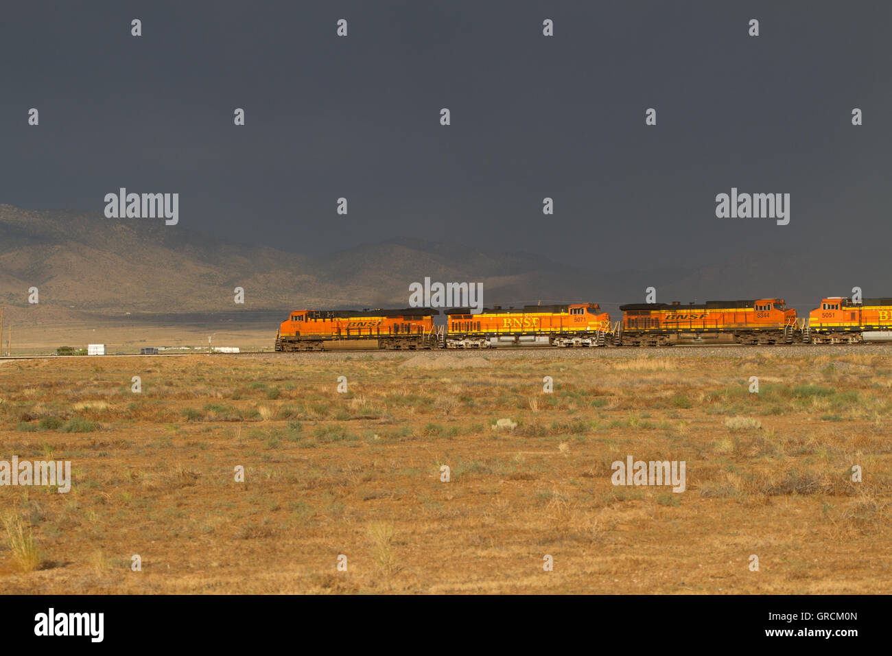 Güterzug durch Wüste mit stürmischen Himmel bewegen. Nevada, USA Stockfoto