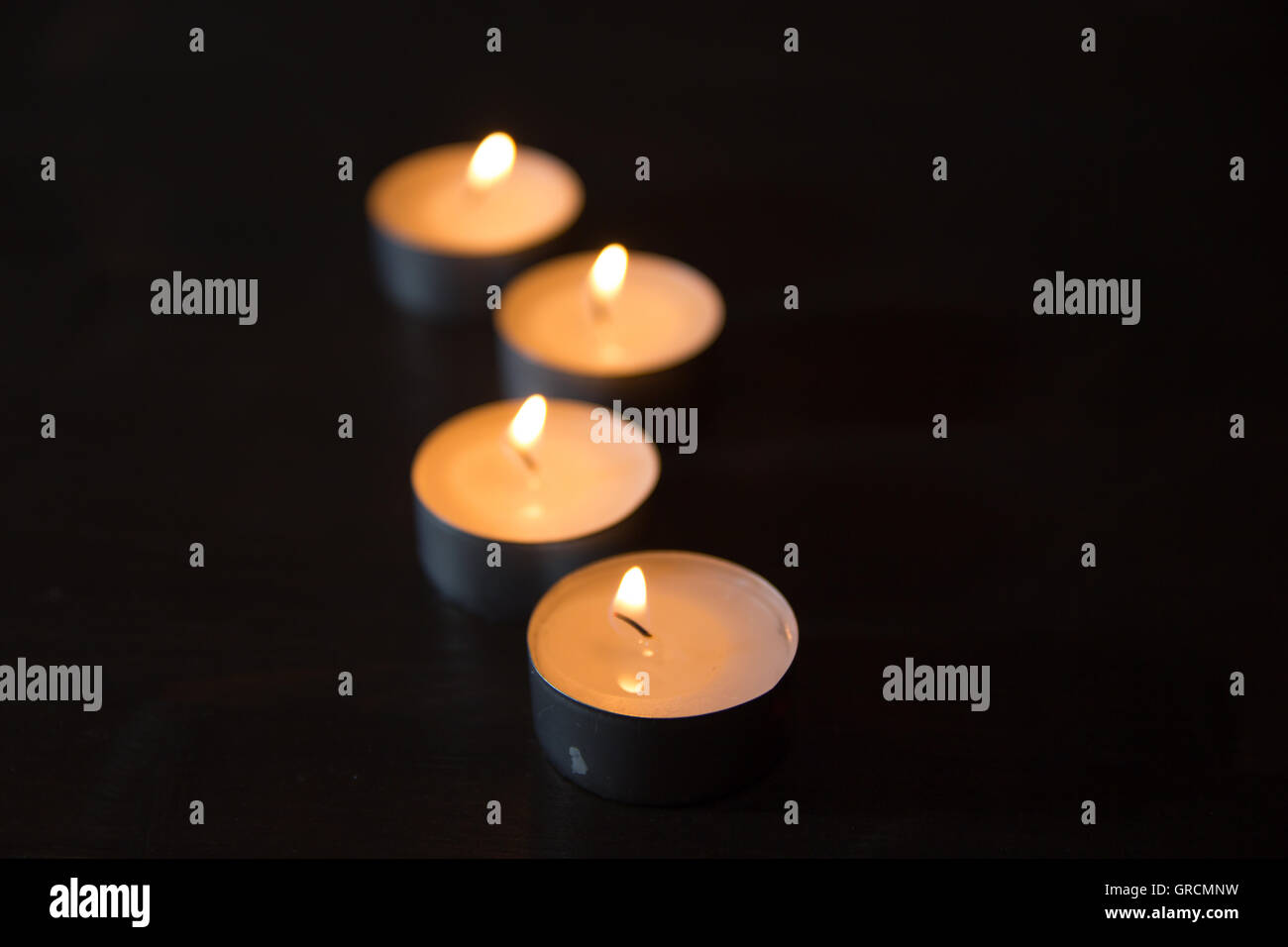 Brennende Kerzen gesehen hintereinander mit Schärfentiefe Stockfoto