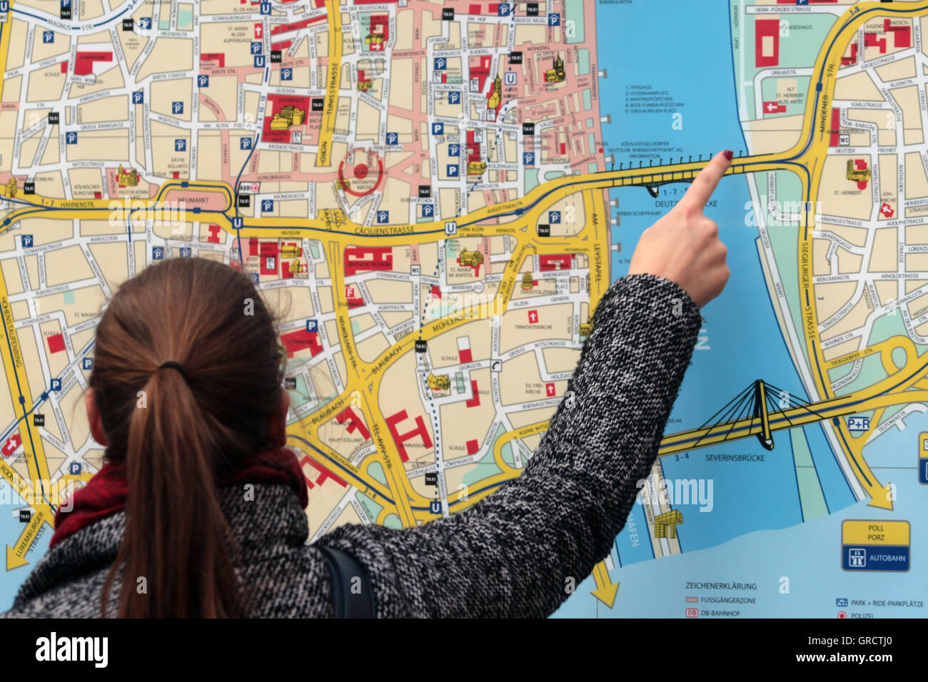 Frau zeigt auf eine Stelle auf einer Stadtkarte In Köln Stockfoto