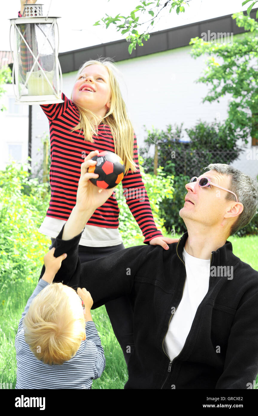 Vater mit junge und Mädchen spielen im Garten Stockfoto