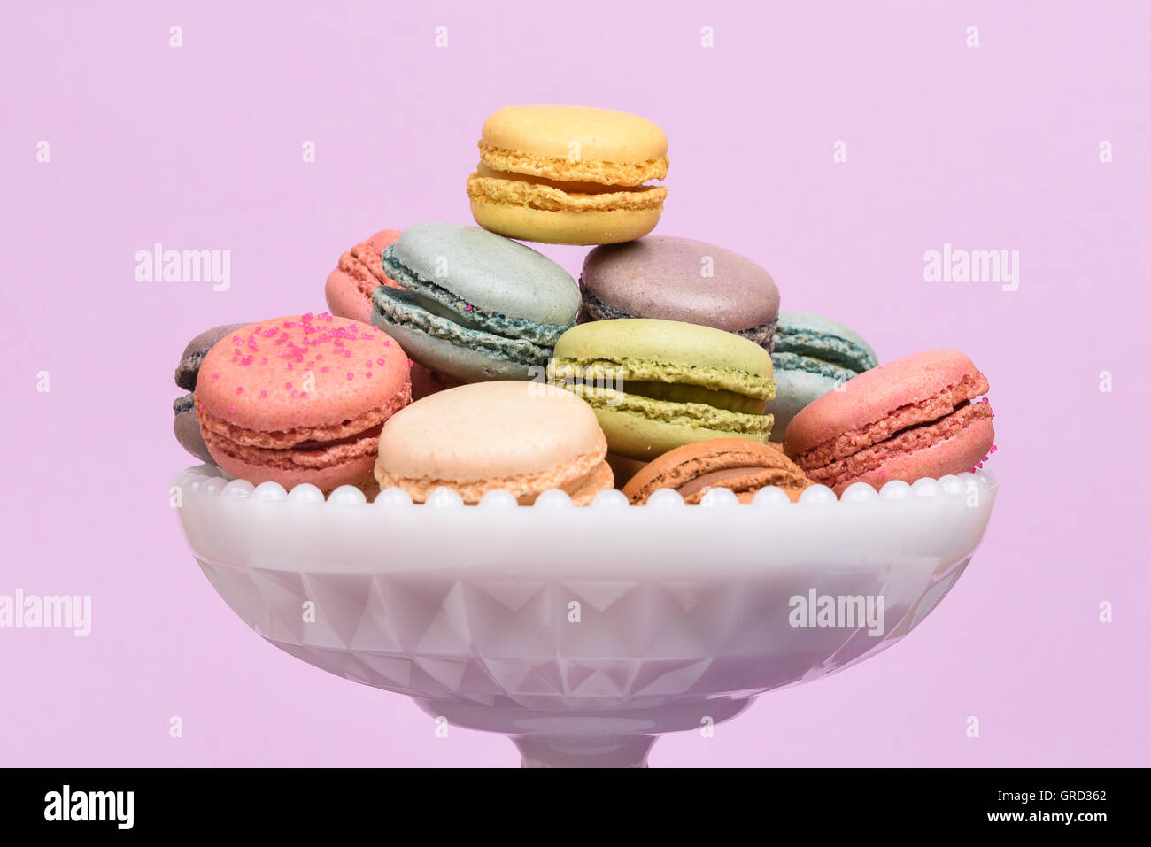 Macarons in einem weißen Sockel Teller gestapelt Stockfoto