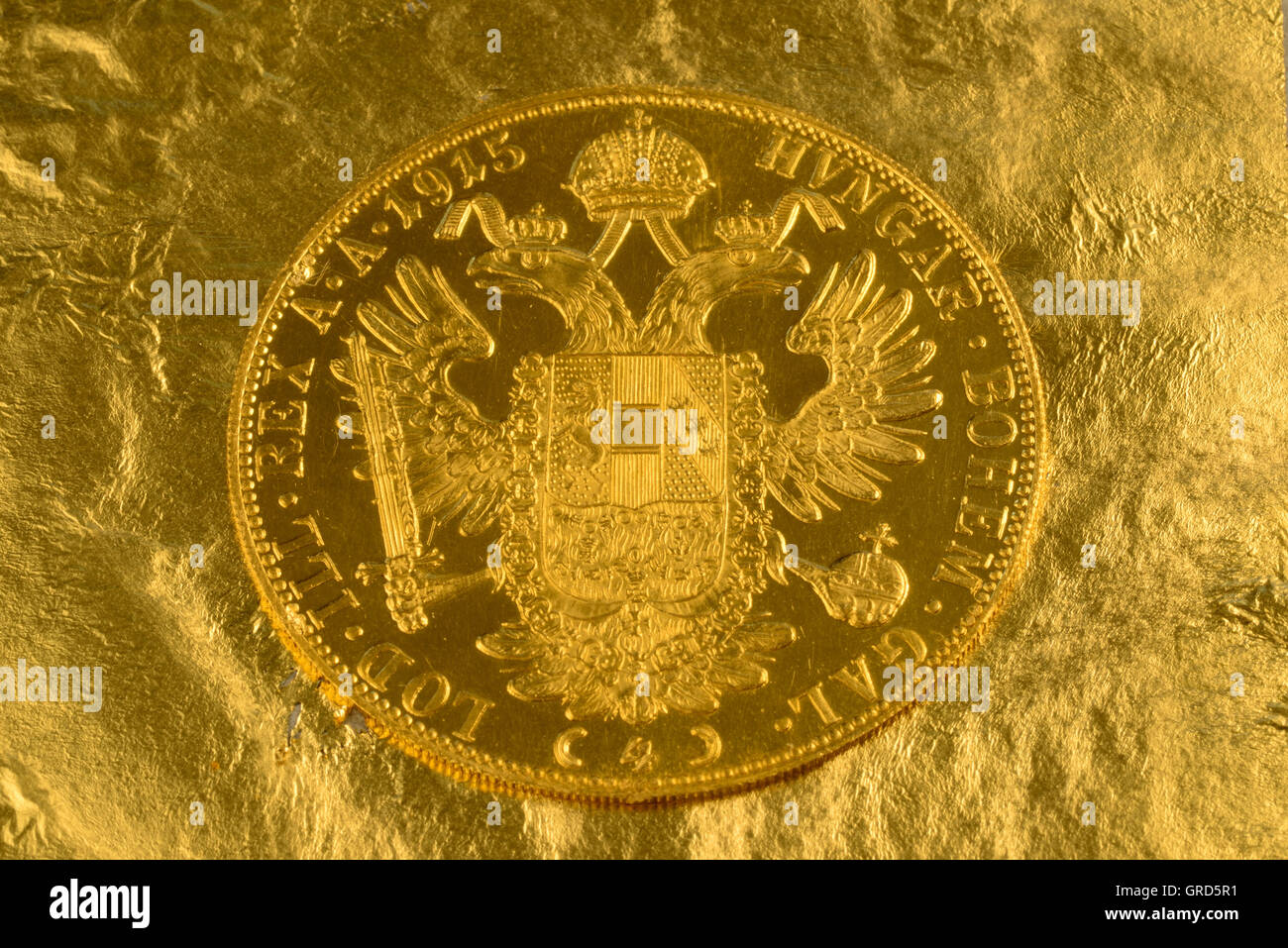 Österreichische Gold Dukat mit goldenem Hintergrund Stockfoto