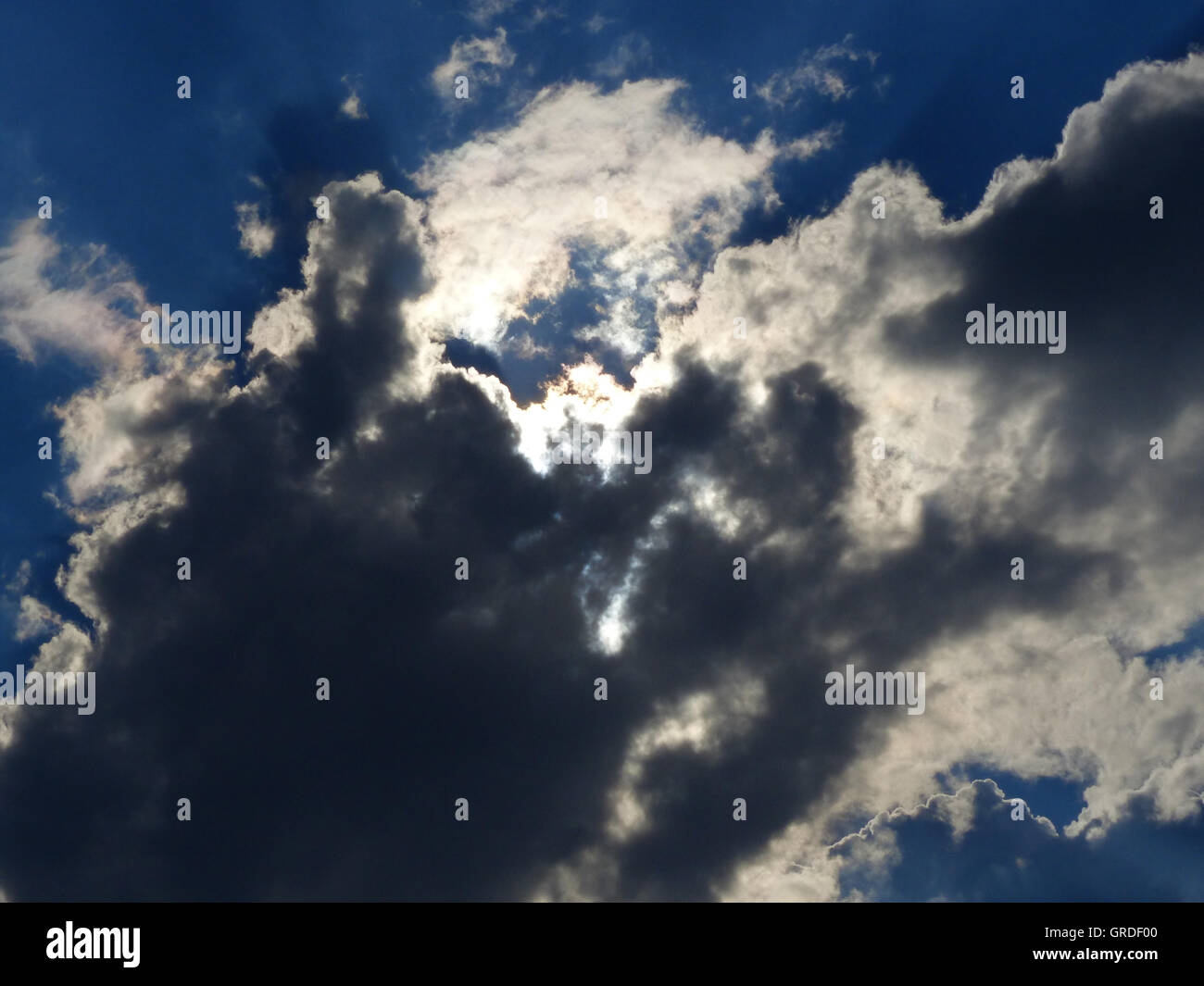 Blauer Himmel mit weißen und schwarzen Wolken, Symbol Blick in den Himmel Stockfoto