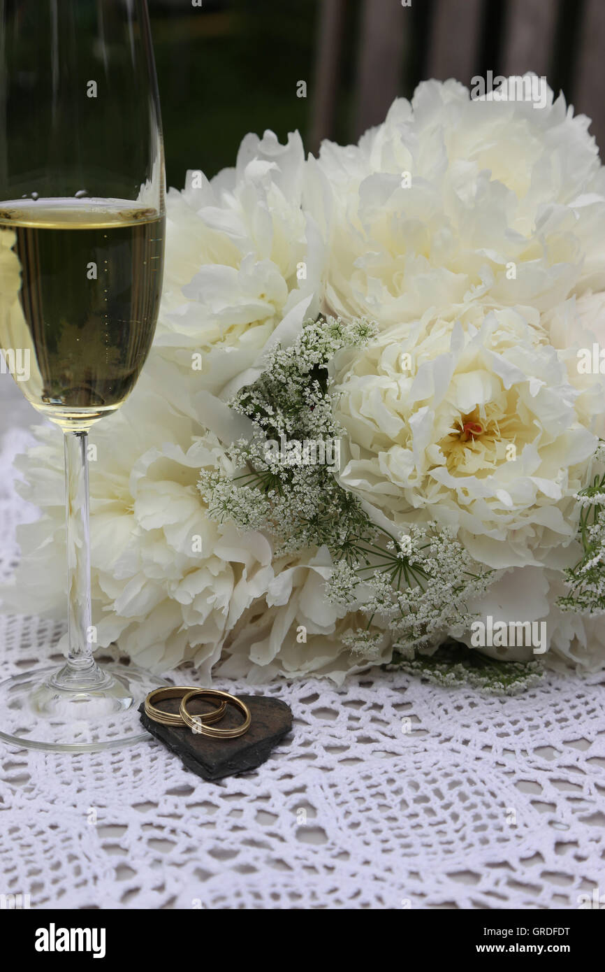 Hochzeit, Brautstrauss, Trauringe und Glas Champagner, Symbolphoto Stockfoto