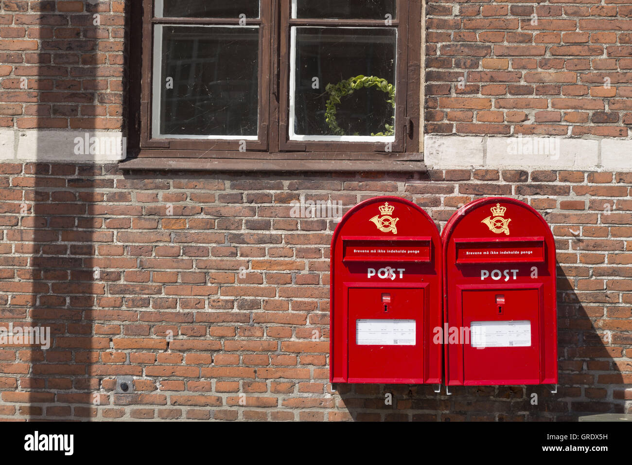 Zwei rote Briefkästen auf Mauer eines Hauses In Stege Dänemark Stockfoto