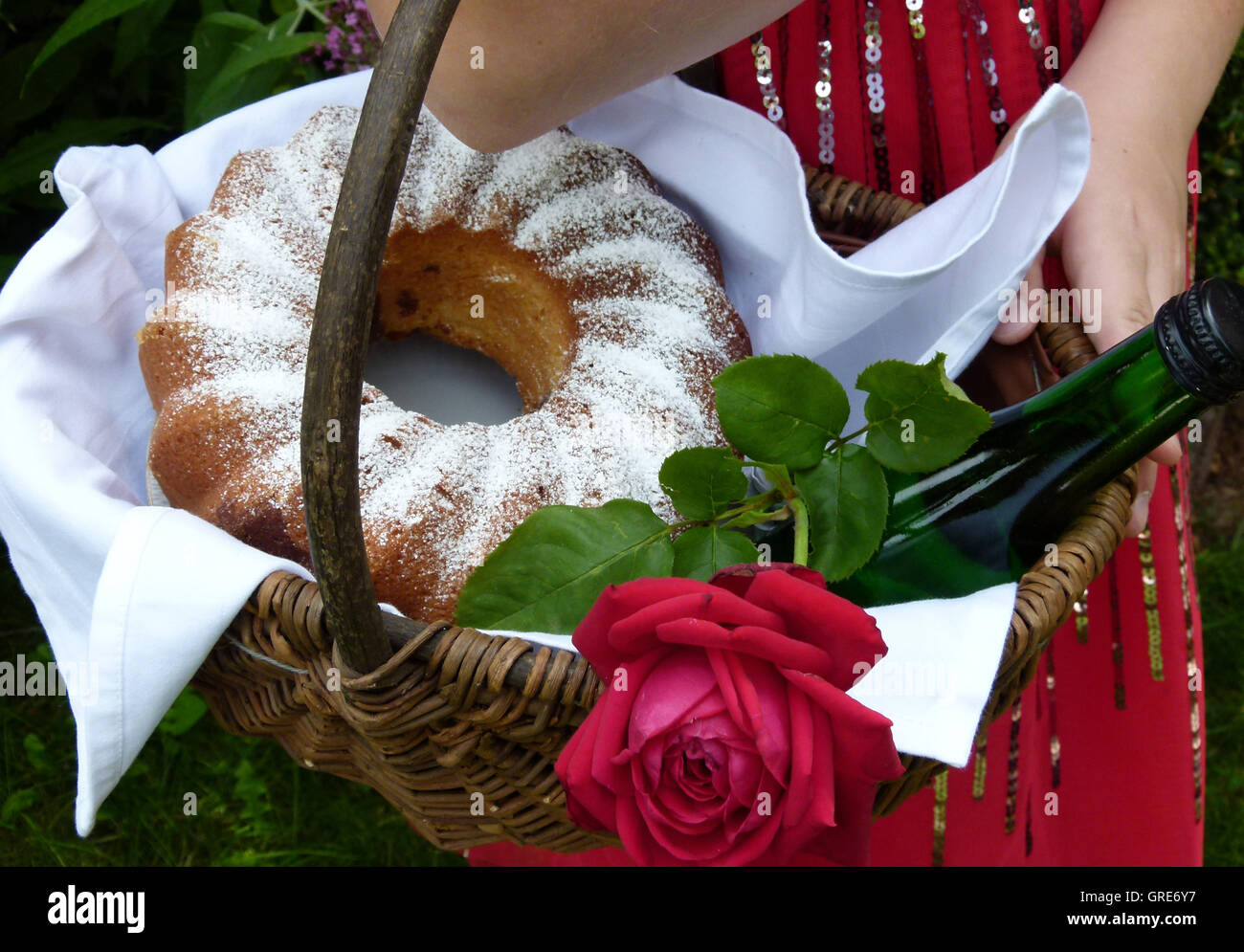 Korb, gefüllt mit einem Kuchen, Wein und eine rote Rose, wie Little Red Riding Hood Stockfoto