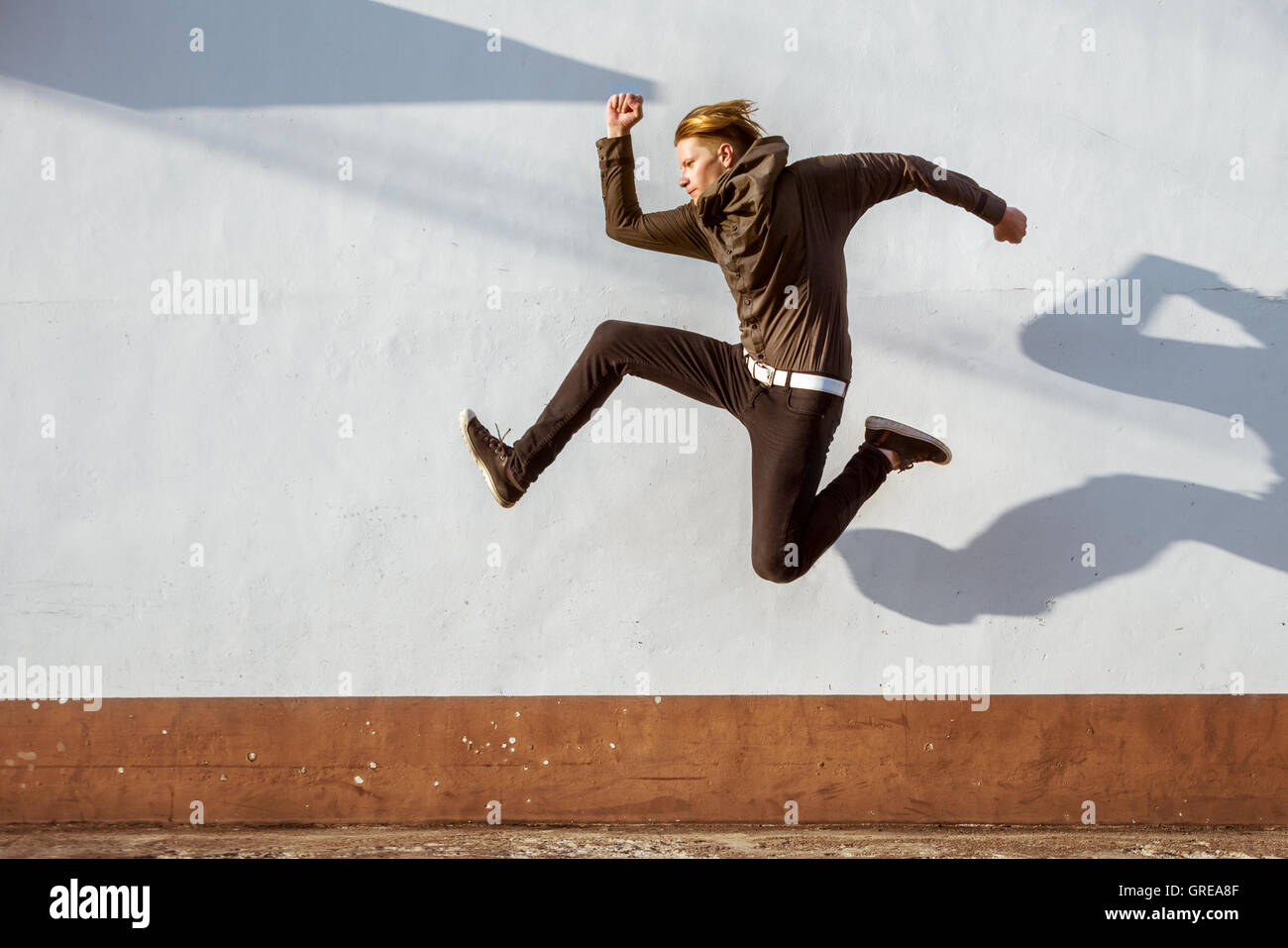 Mann Closeup weiße Wand springen Stockfoto