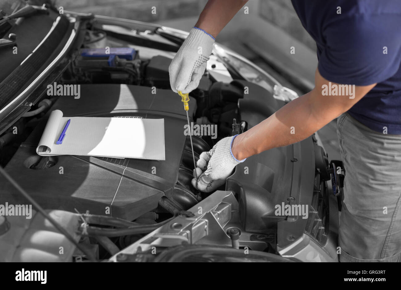 Kfz-Mechaniker-den Ölstand im Motor prüfen Stockfoto