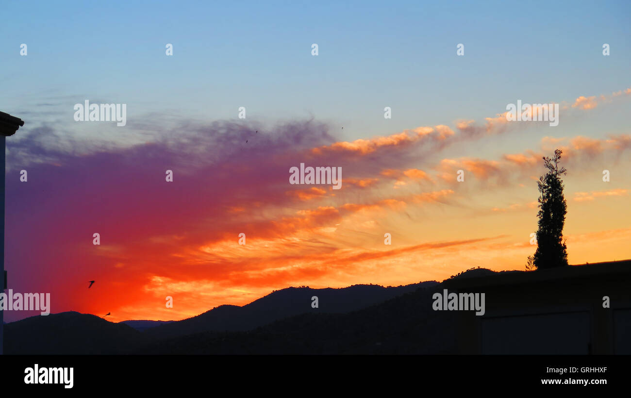 Silhouette in orange Dawn Wolken im Dorf von Alora Andalusien Stockfoto