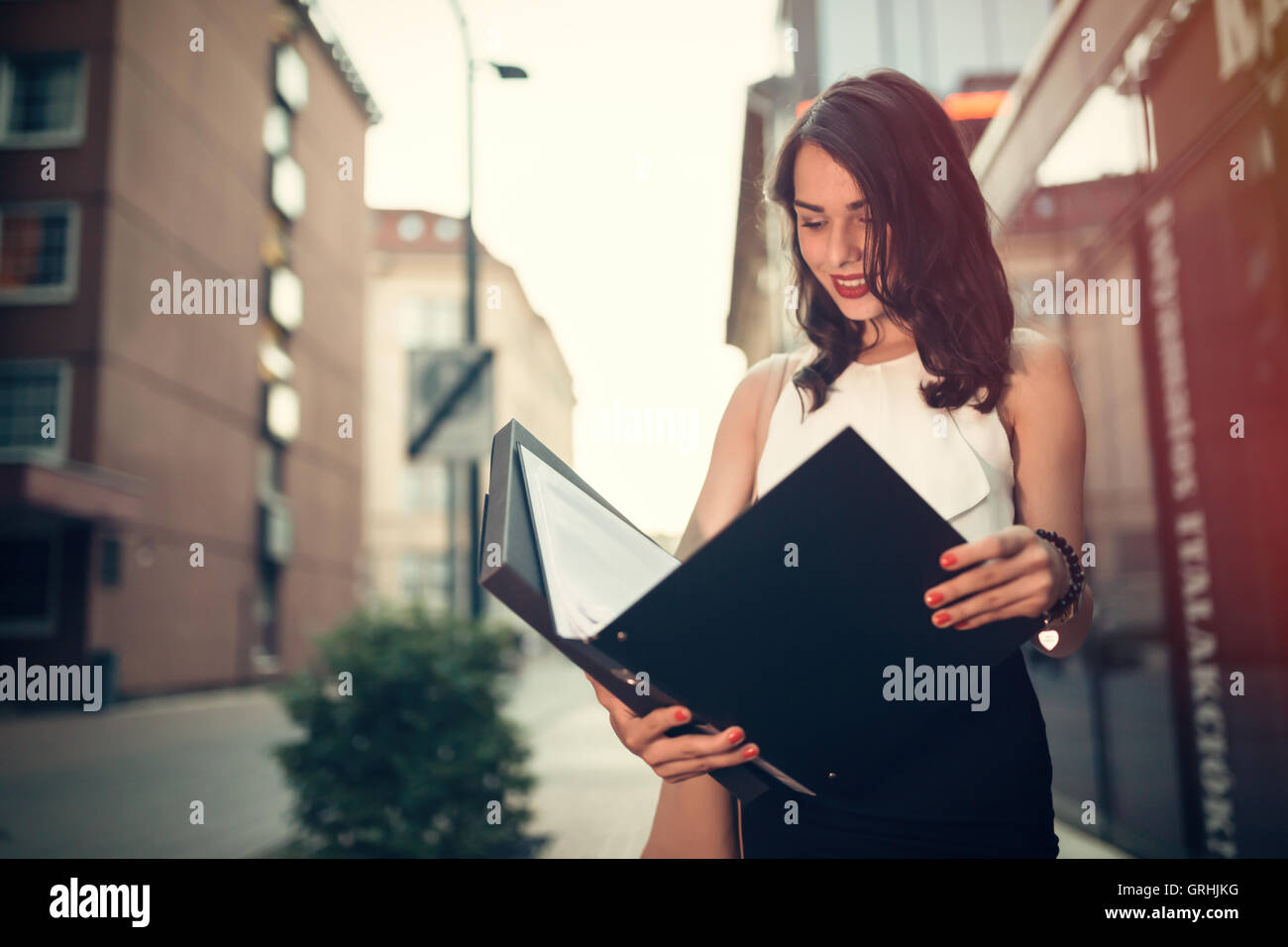 Geschäftsfrau lesen außerhalb während des Gehens Stockfoto