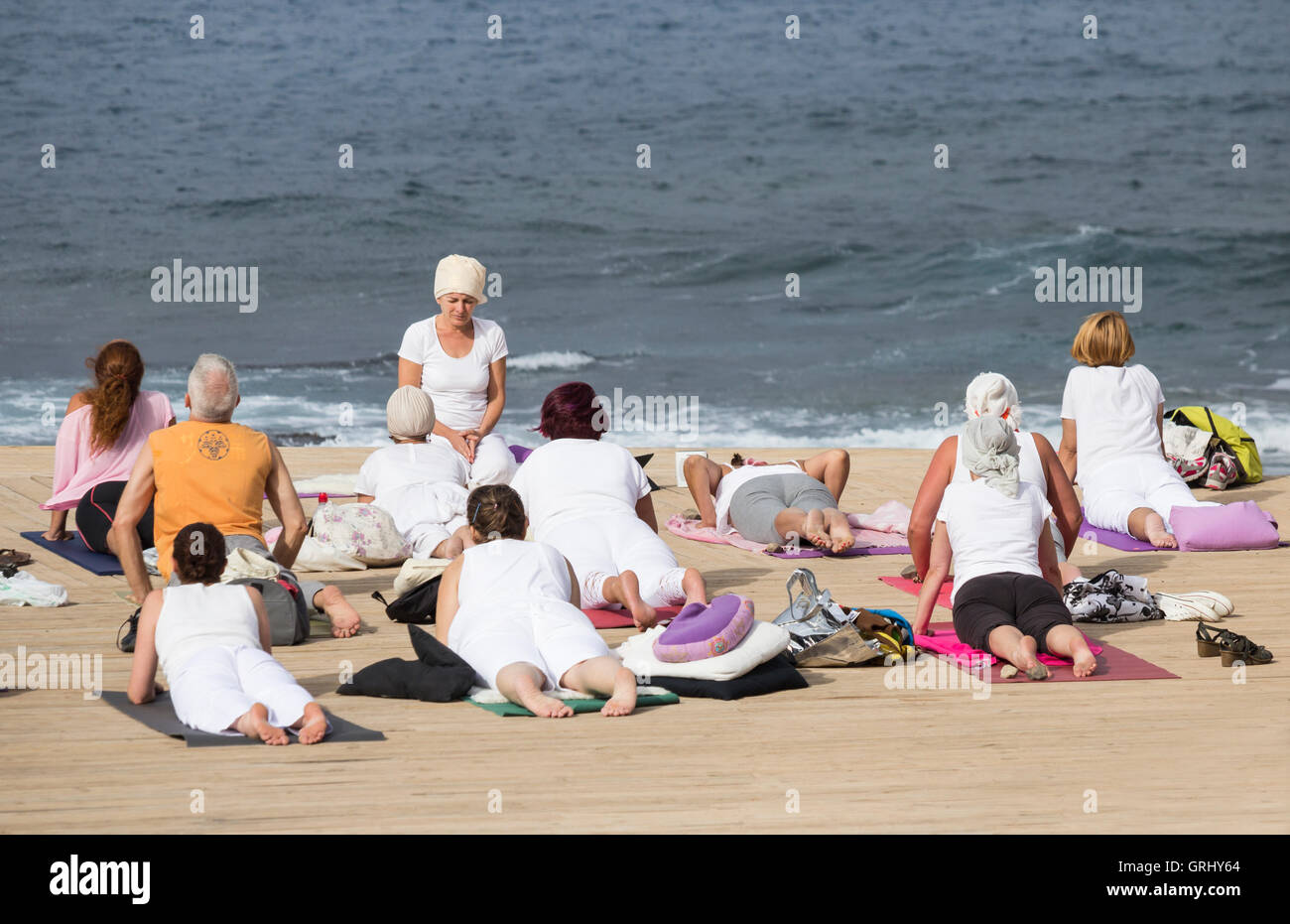 Yoga-Kurs am Strand mit Meer im Hintergrund. Stockfoto