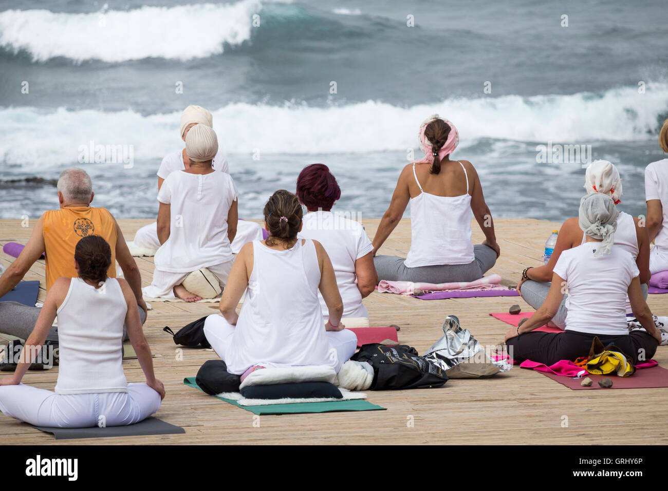 Yoga-Kurs am Strand mit Meer im Hintergrund. Stockfoto
