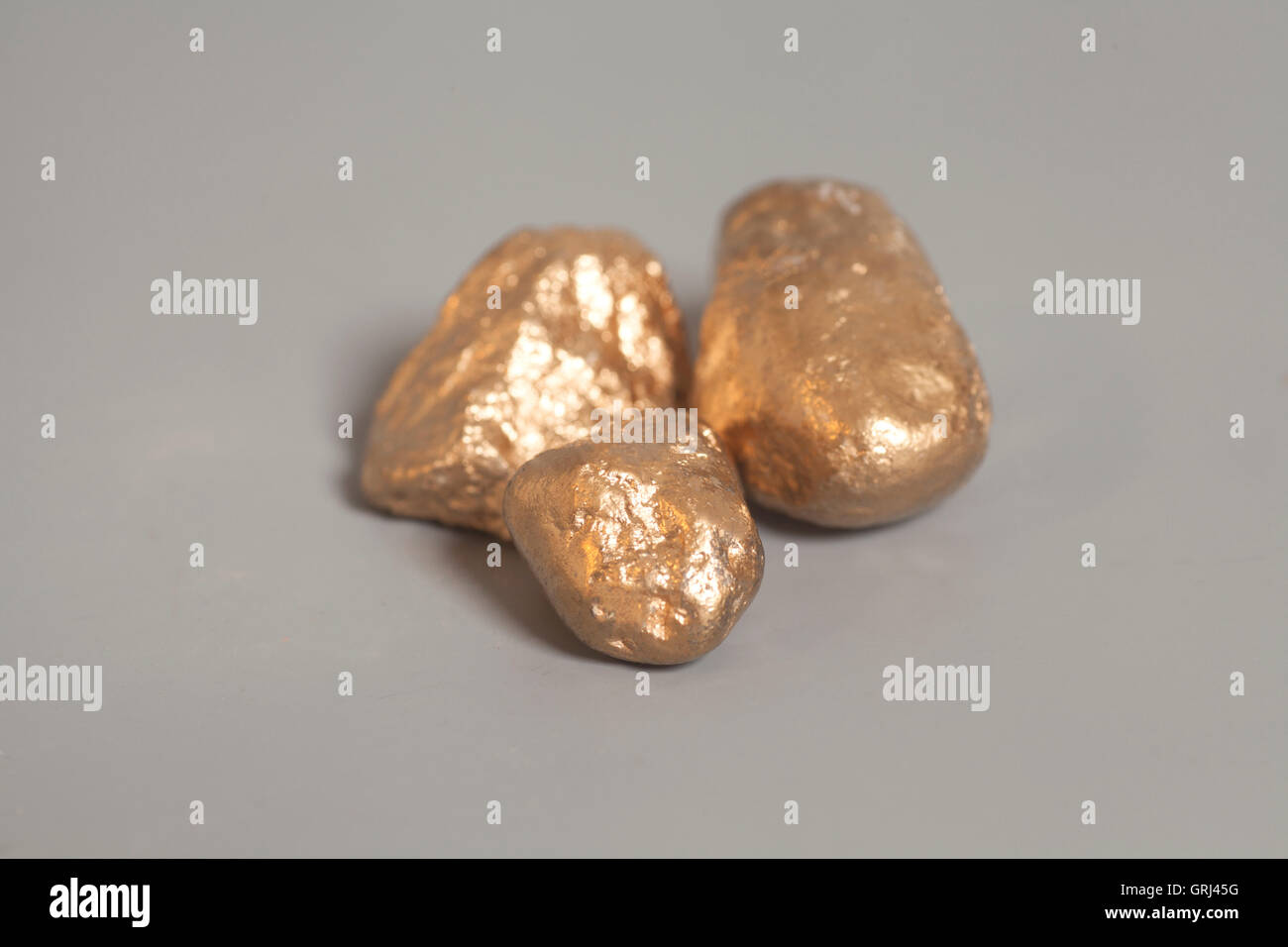 Golden Nuggets auf grauem Hintergrund Stockfoto