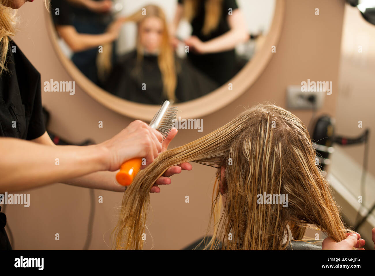Friseur am Arbeitsplatz - Kämmen Haare an den Kunden zuvor Frisur in einem professionellen Salon Friseur Stockfoto