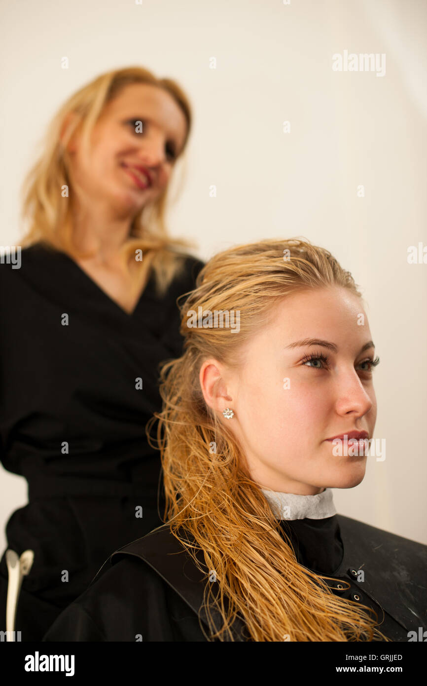 Friseur am Arbeitsplatz - Friseur und Kunde Bewertung Haar nach Haarschnitt und Frisur in einem professionellen Sal vorher Stockfoto