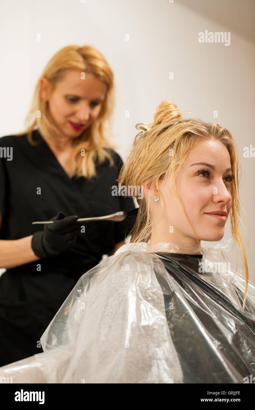Friseur am Arbeitsplatz - eine Farbe auf Kunden Haar anwenden, nach Haarschnitt und Frisur in einem Ei vorher Friseur Stockfoto