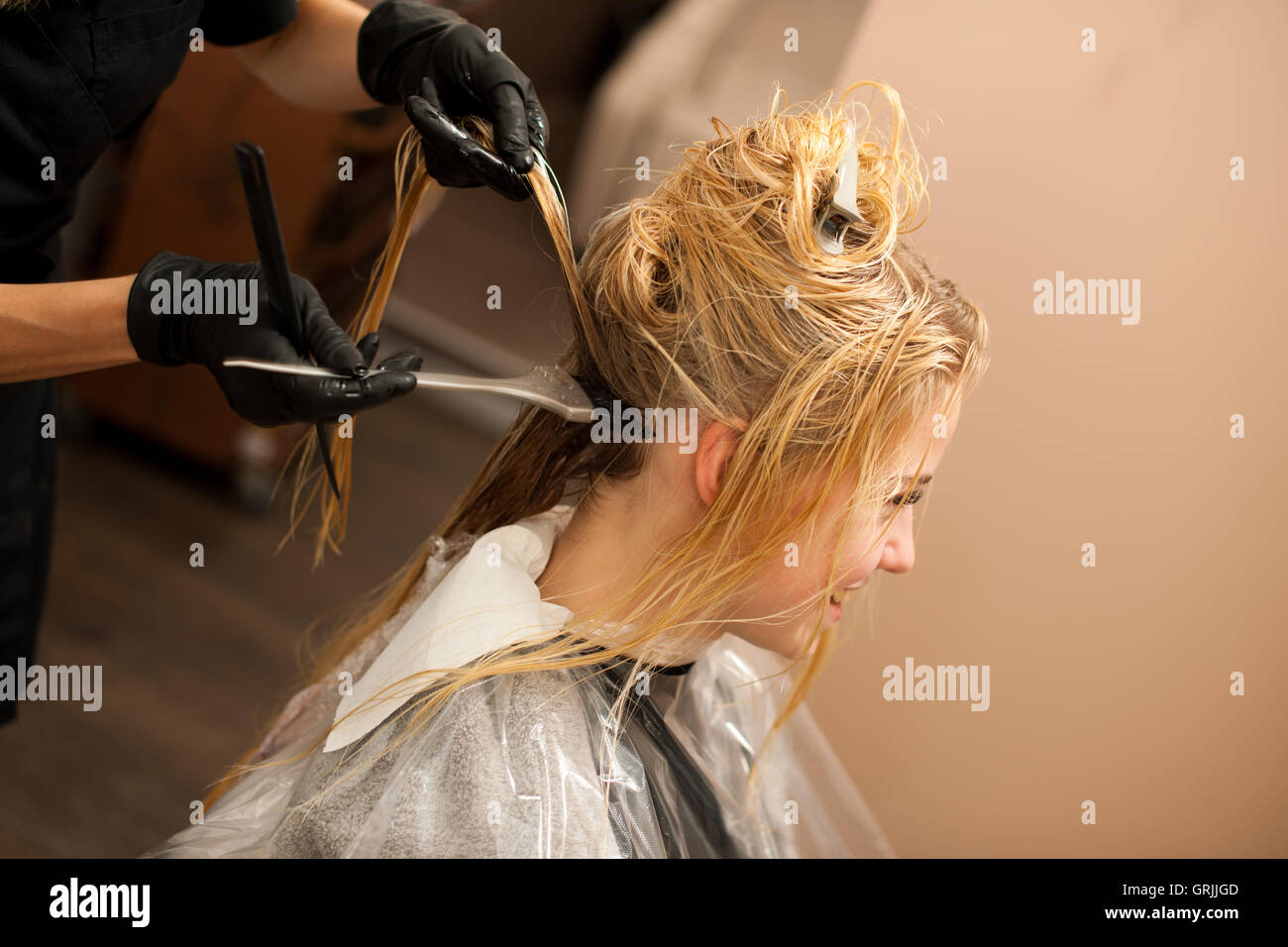 Friseur am Arbeitsplatz - eine Farbe auf Kunden Haar anwenden, nach Haarschnitt und Frisur in einem Ei vorher Friseur Stockfoto