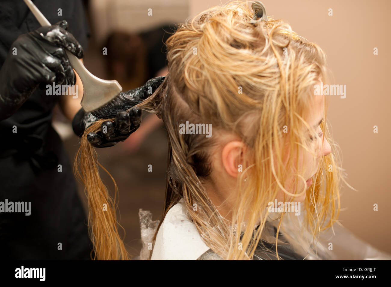 Friseur am Arbeitsplatz - eine Farbe auf Kunden Haar anwenden, nach Haarschnitt und Frisur in einem Ei vorher Friseur Stockfoto