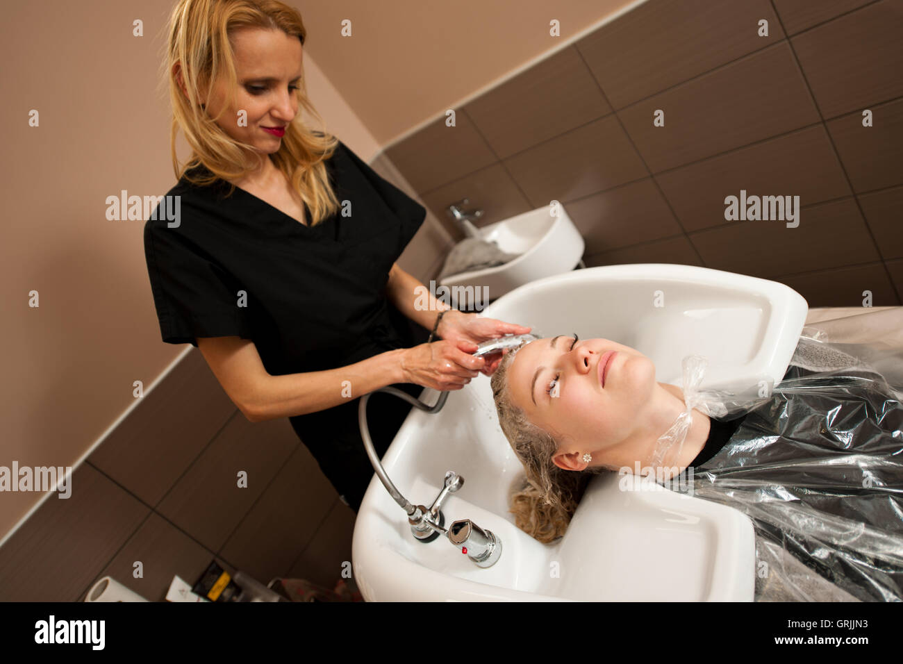 Friseur am Arbeitsplatz - Friseur waschen Haare an den Kunden zuvor Frisur Stockfoto
