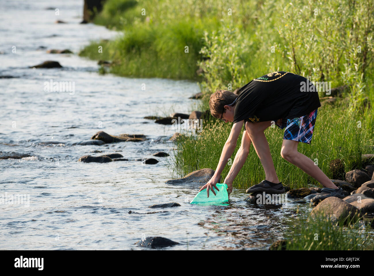 Ein Pfadfinder sammelt Wasser zum Kochen von den Clearwater River in Idaho Orofino während der Fahrt auf der Originalroute Lewis and Clark Trail und Kanu. Stockfoto