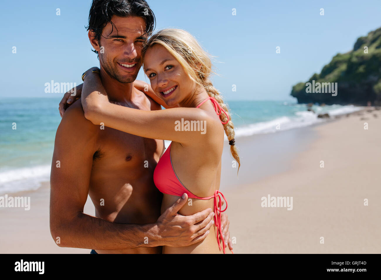 Schuss von schöne junge Paar am Strand umarmen. Junger Mann und Frau zusammen an einem tropischen Strand. Stockfoto