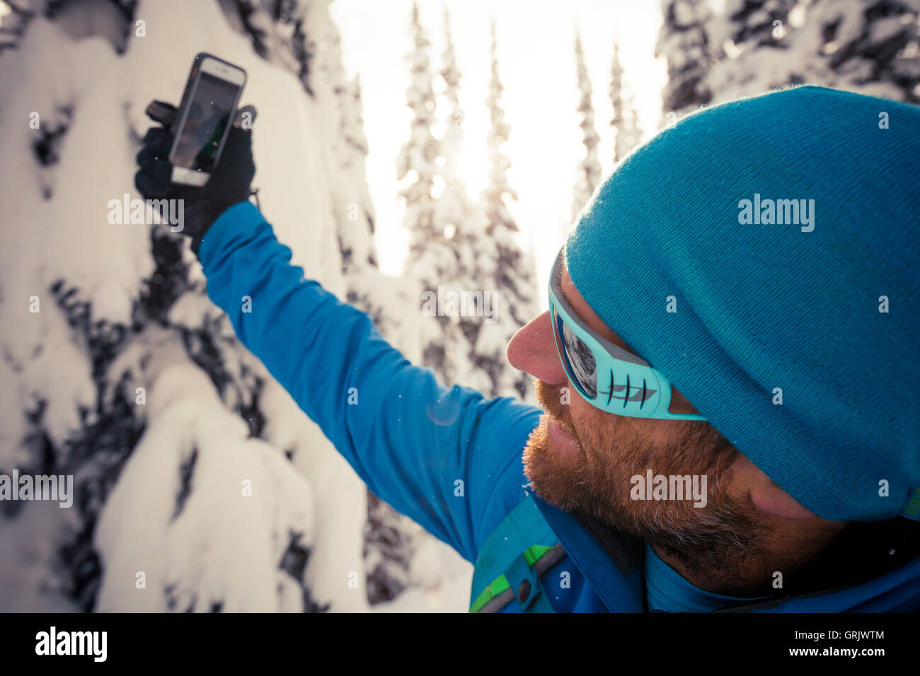 Backcountry Skifahrer stoppt, um ein Selbstporträt mit seinem Smartphone zu nehmen Stockfoto