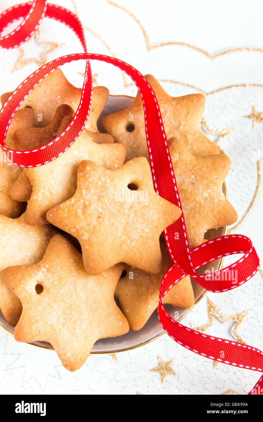 Weihnachten Lebkuchen auf weiße Serviette mit Sternen und rotes Band für Winterurlaub Stockfoto