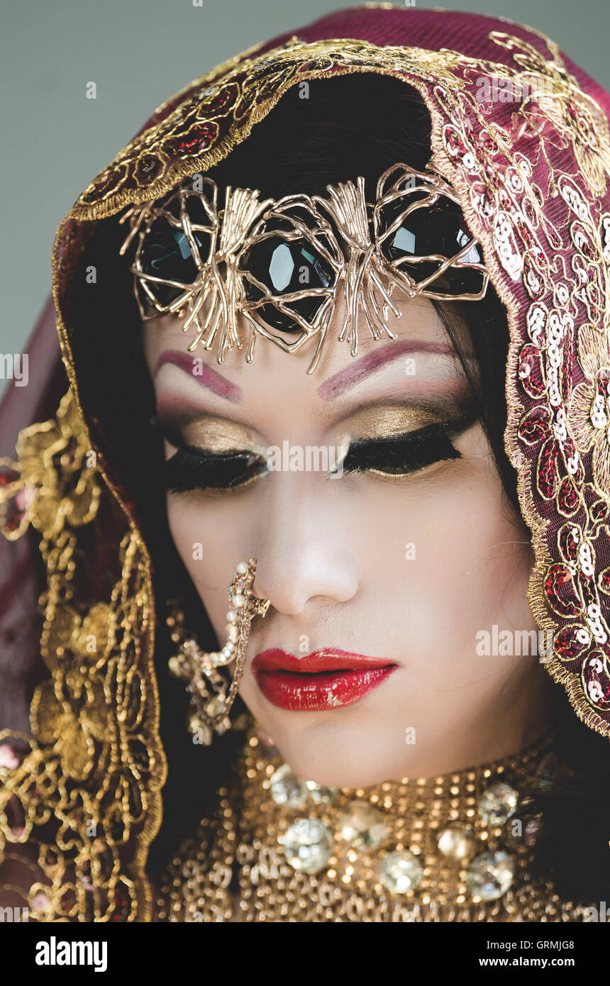 Kopfschuss Frau gekleidet in traditionellen hinduistischen Kleidung stark verziert in gold und elegante Schleier, künstlerisch posiert für Kamera, Hinduismus Tänzerin Konzept Stockfoto