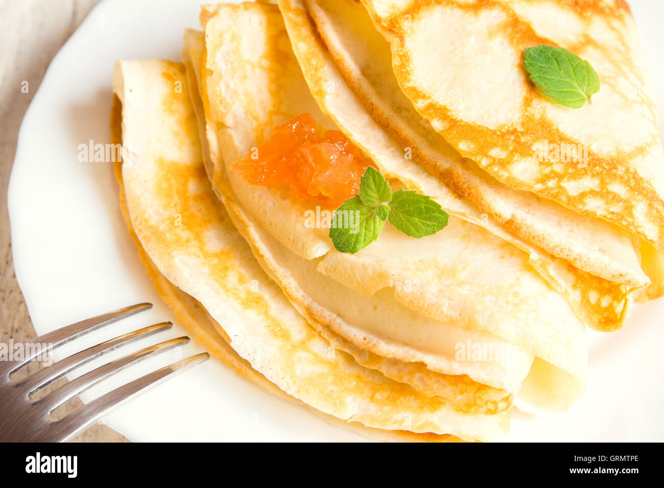 Pfannkuchen mit Apfel Marmelade und Minze auf weißen Teller Stockfoto