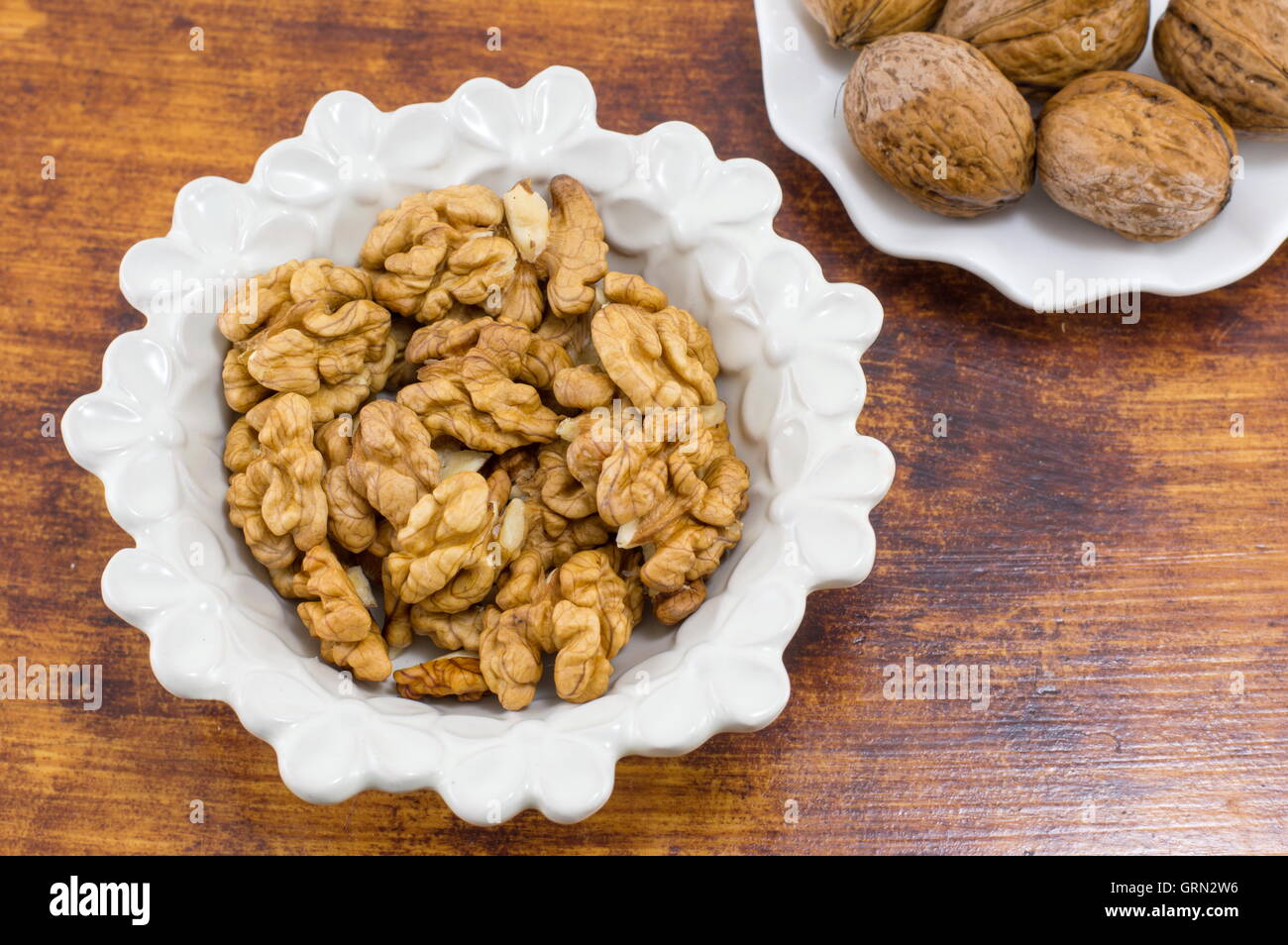 Frische Walnüsse in einer weißen Schüssel auf dem Tisch Stockfoto